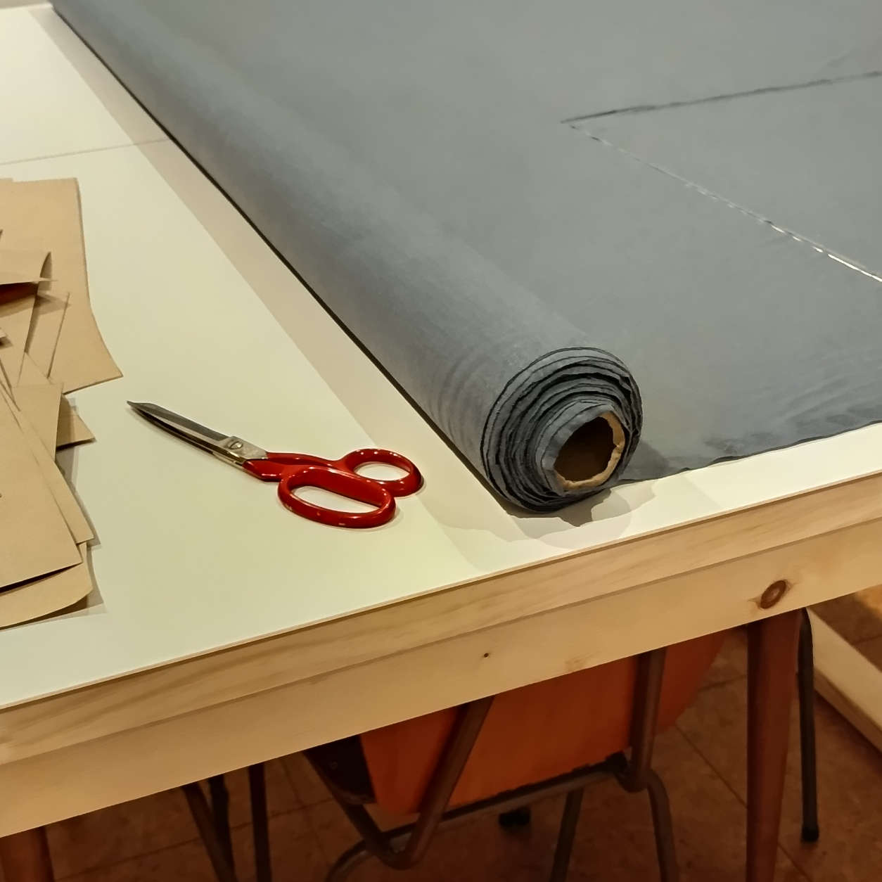 A roll of merino fabric on the cutting table.