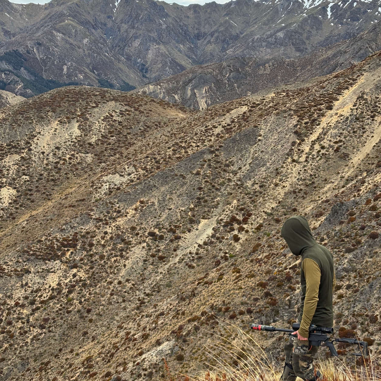 A hunter wearing a Wild Balance hoodie in the alpine tops.